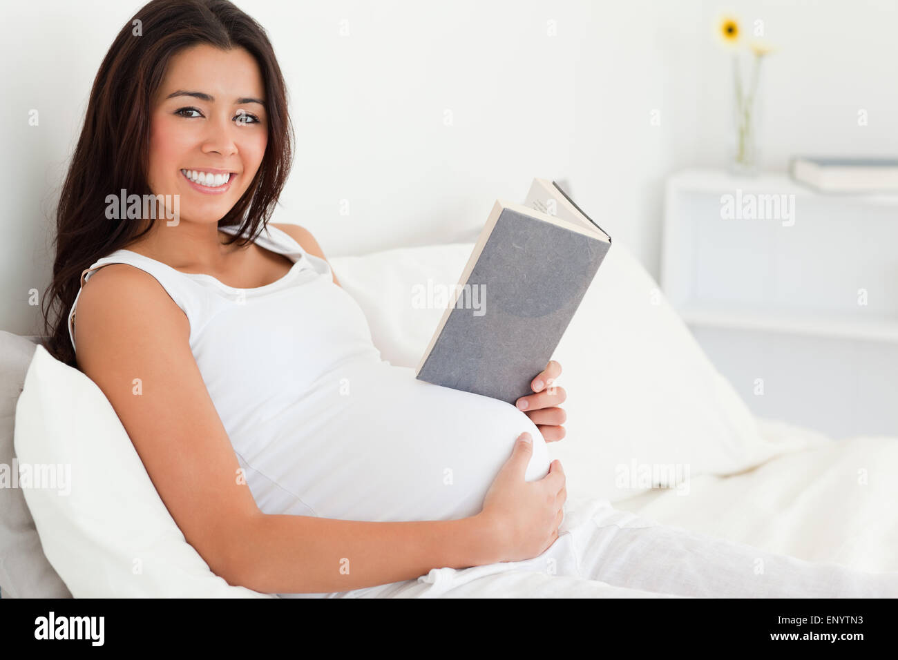беременная читает иллюстрации. беременная женщина читает книгу на диване. девушка в библиотеке. беременная лежит с книгой. Pregnancy reader.