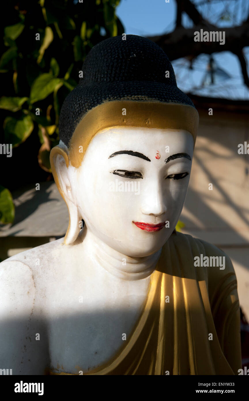 Close up of shadowy face of a painted marble Buddha statue in Maymyo Myanmar Stock Photo