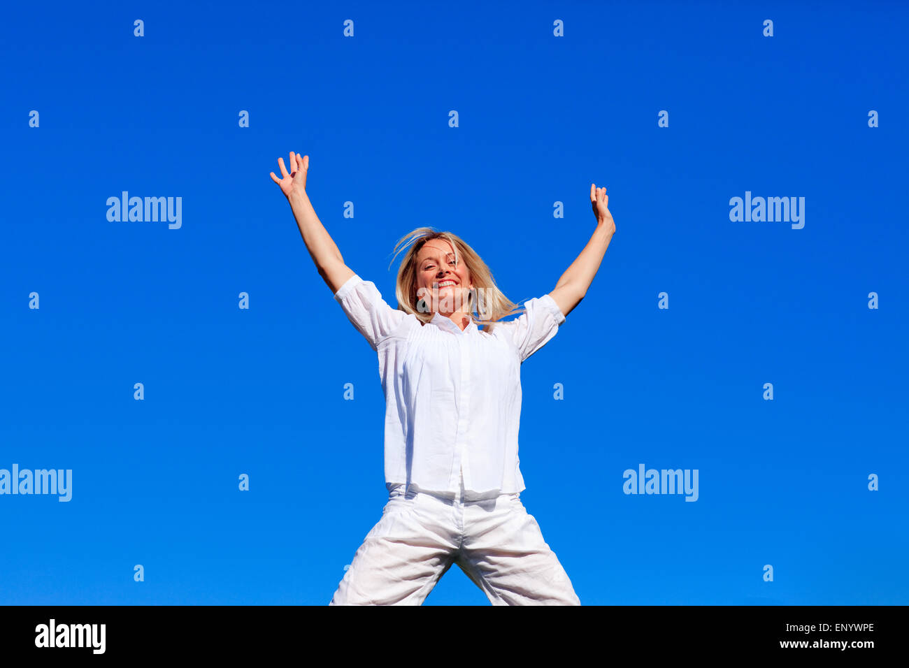 Happy girl jumping against blue sky Stock Photo - Alamy