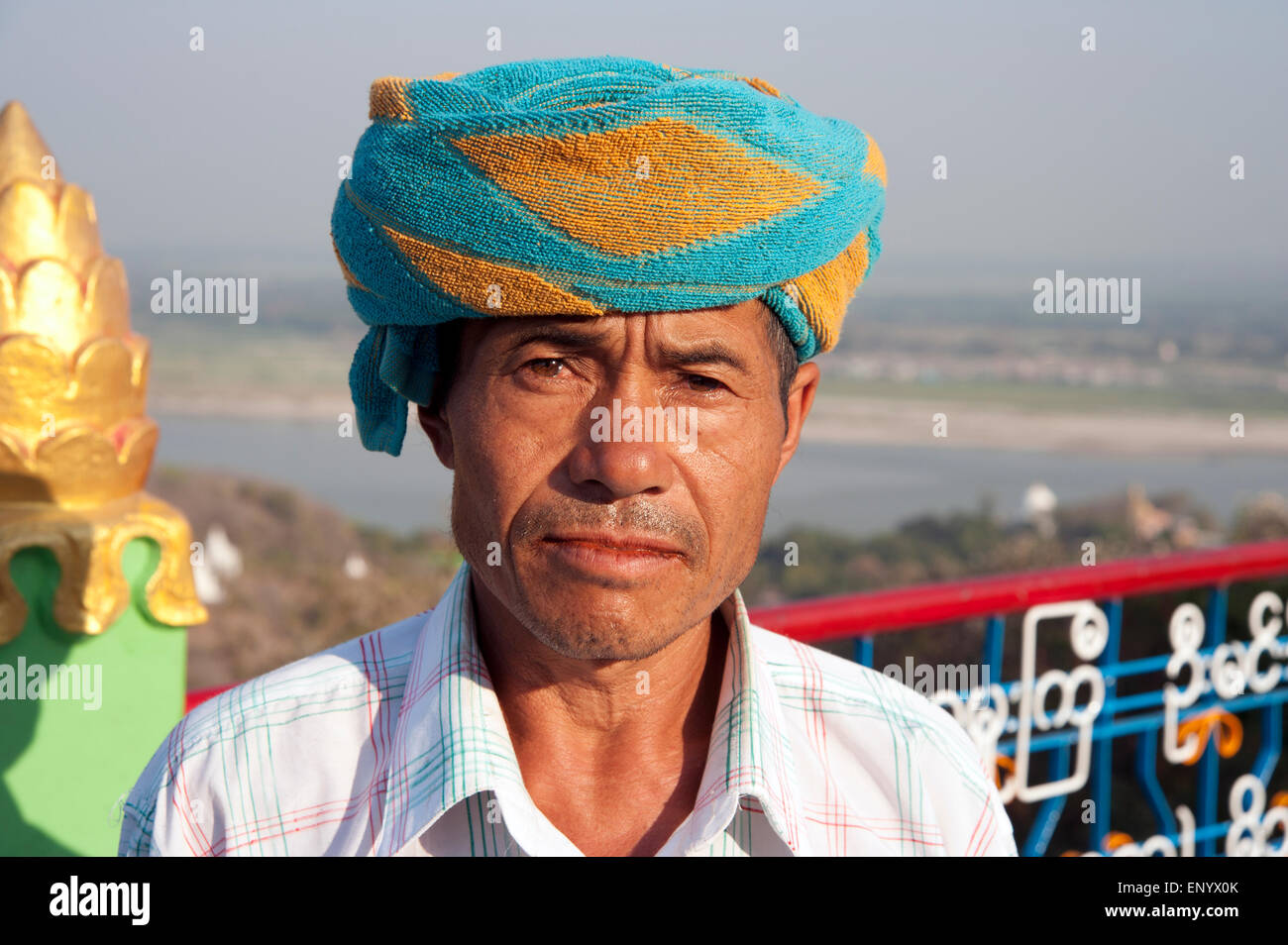 Portrait of a tribal man wearing a colourful turban overlooking the Ayeyarwady river from a temple in Sagaing Myanmar Stock Photo