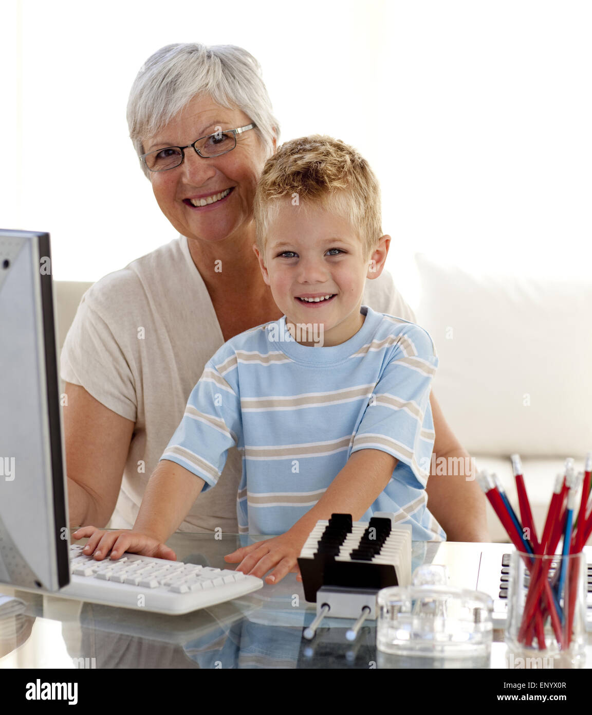 Happy grandson using a computer with his grandmother Stock Photo - Alamy