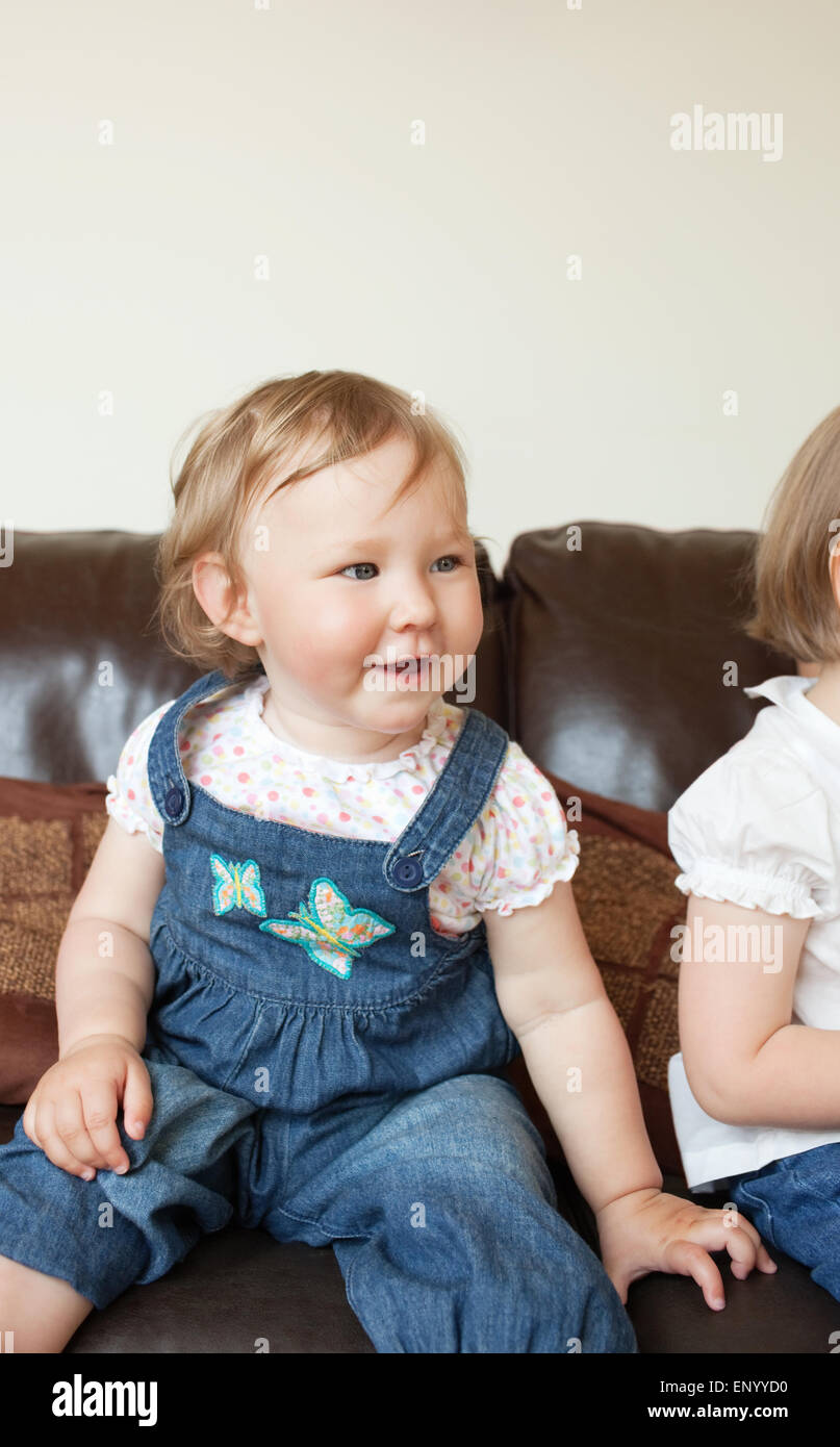 Smiling girl sitting on the sofa Stock Photo - Alamy