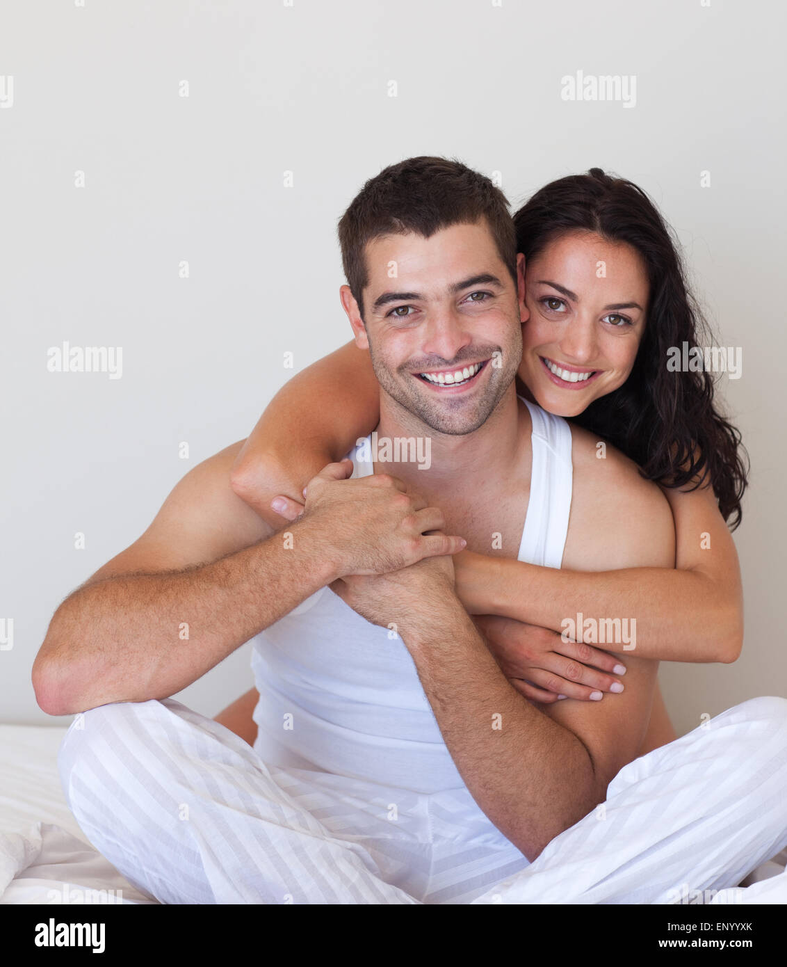 Smiling beautiful girl hugging her attractive boyfriend Stock Photo - Alamy