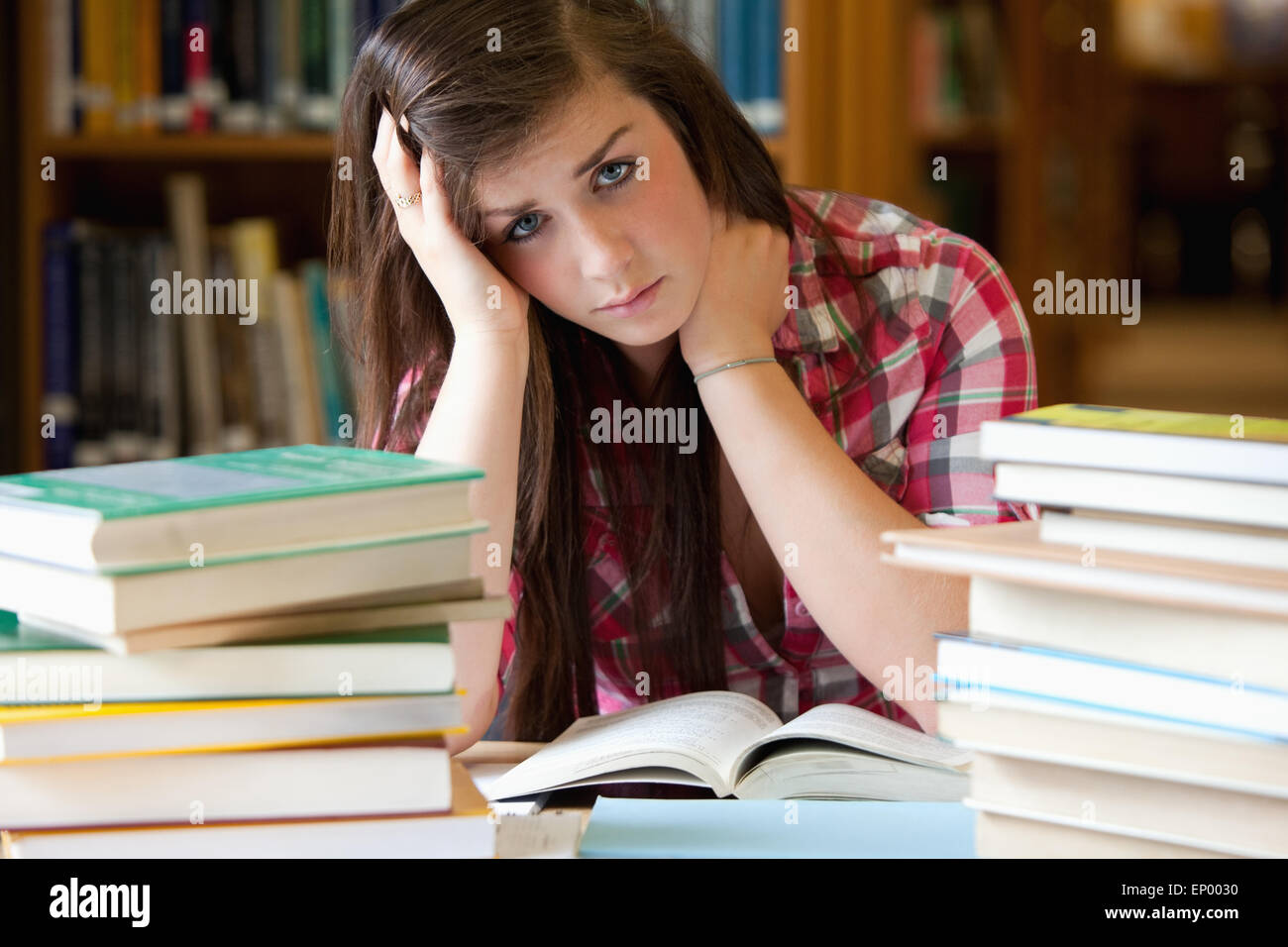 Depressed student surrounded by books Stock Photo - Alamy