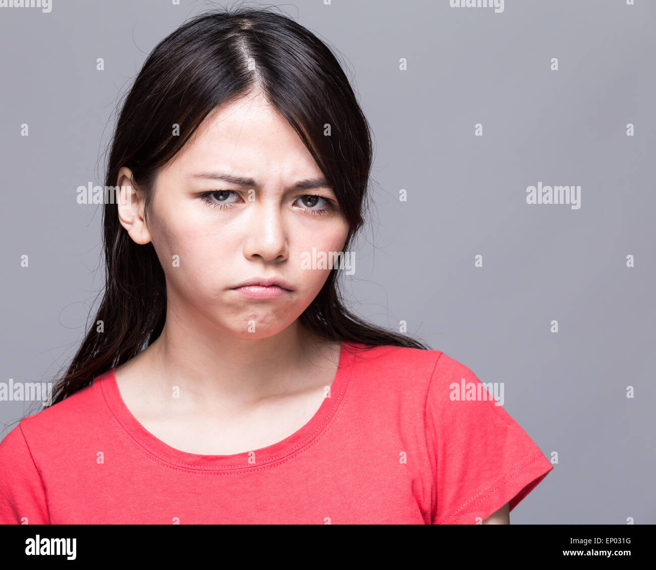 Upset Chinese woman scowling Stock Photo