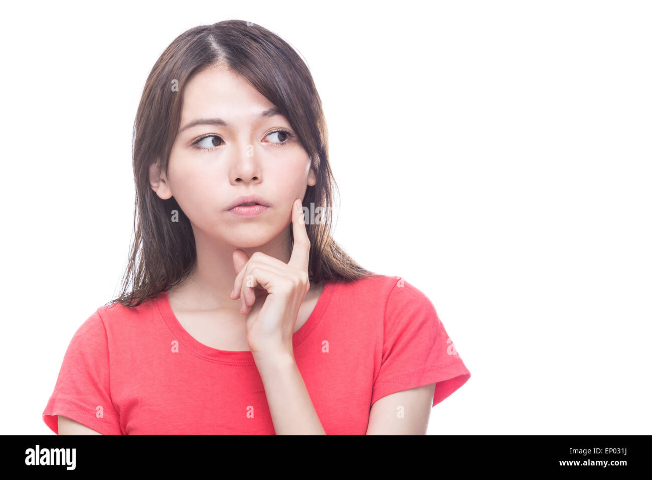 Chinese woman with hand on face looking to side, thinking Stock Photo