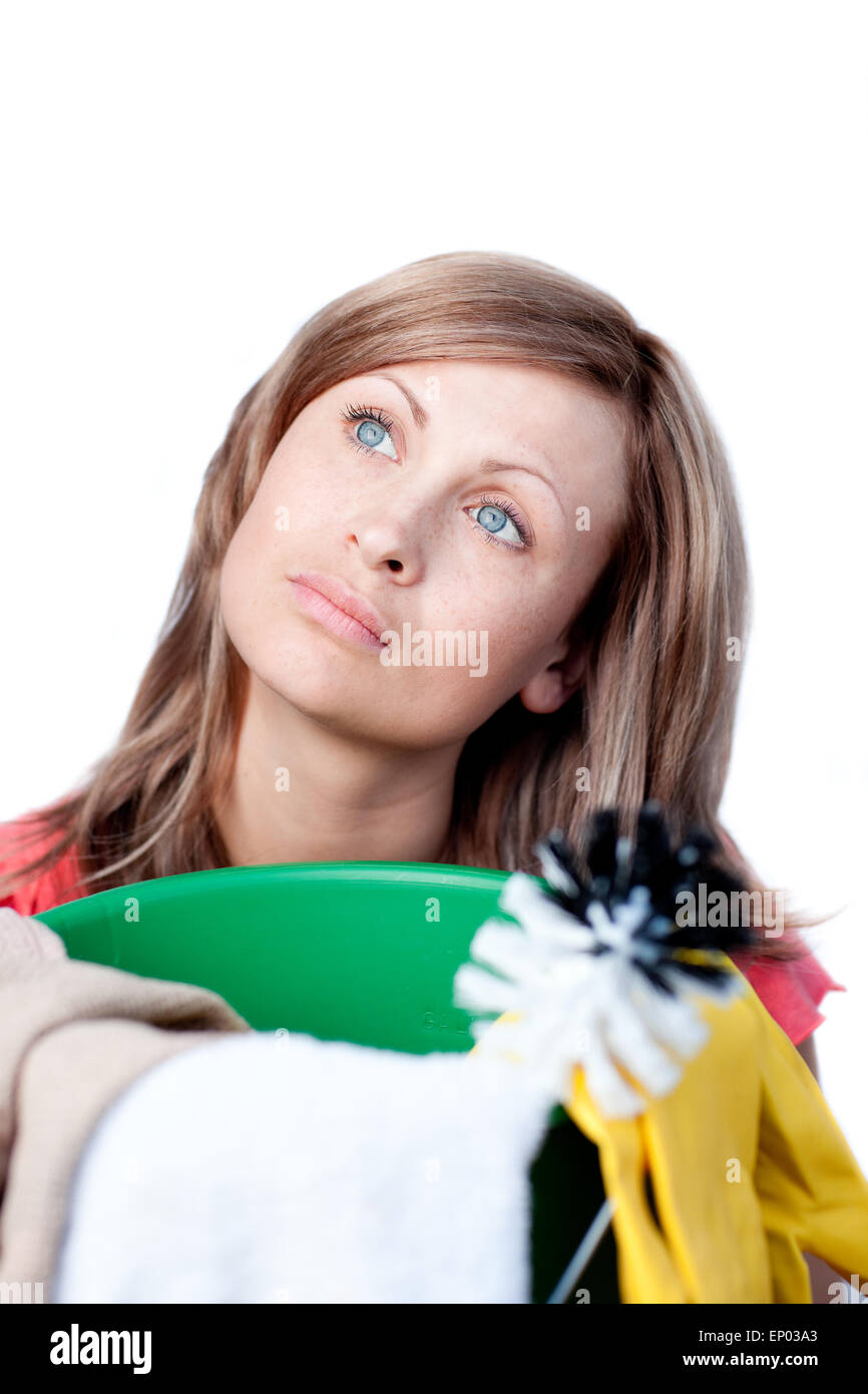 Portrait of a delighted woman doing housework against a white ...