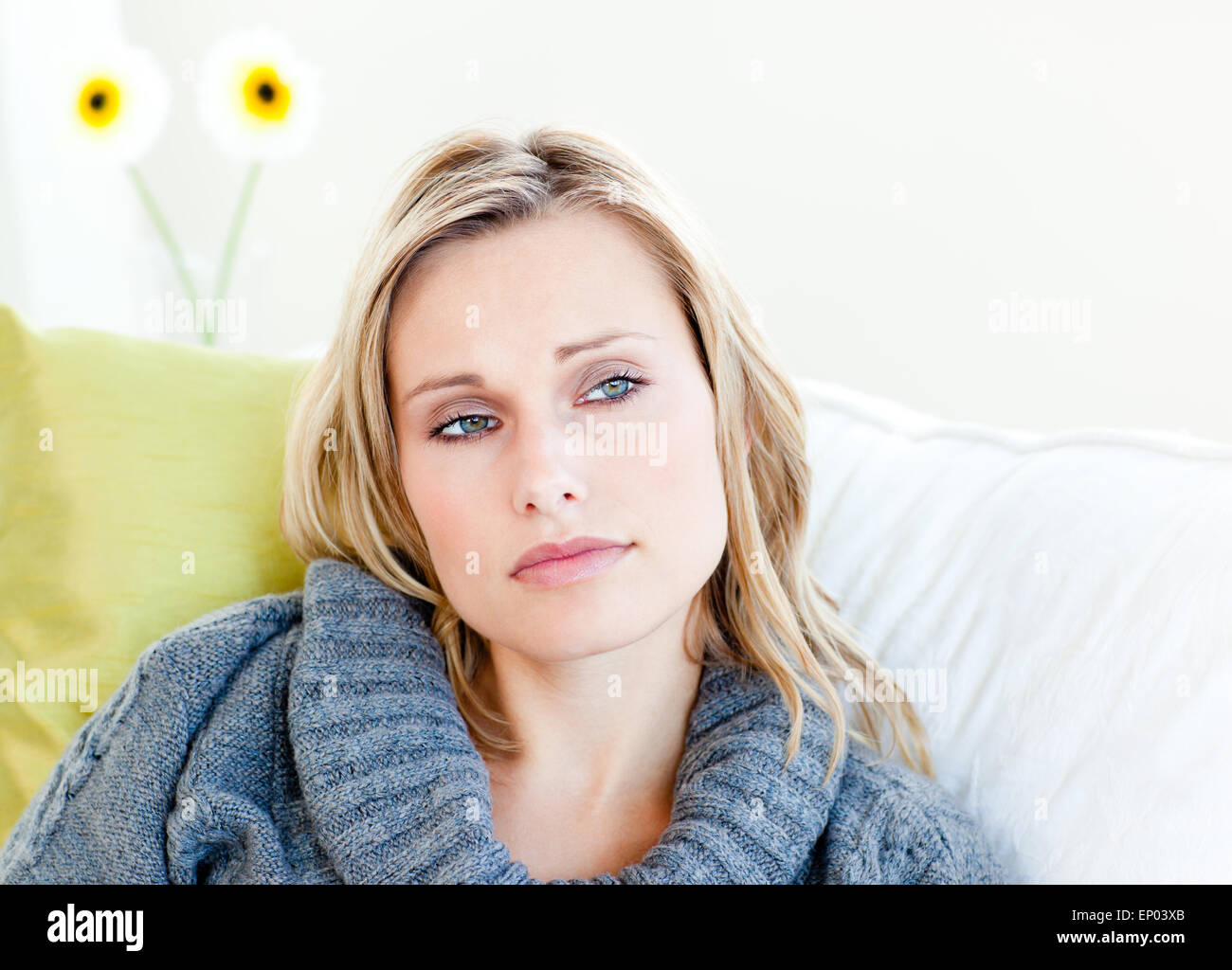 Exhausted woman lying on the sofa with a grey pullover Stock Photo - Alamy