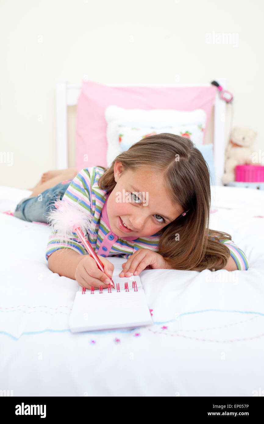 Cute Little girl writing on a notebook Stock Photo Alamy