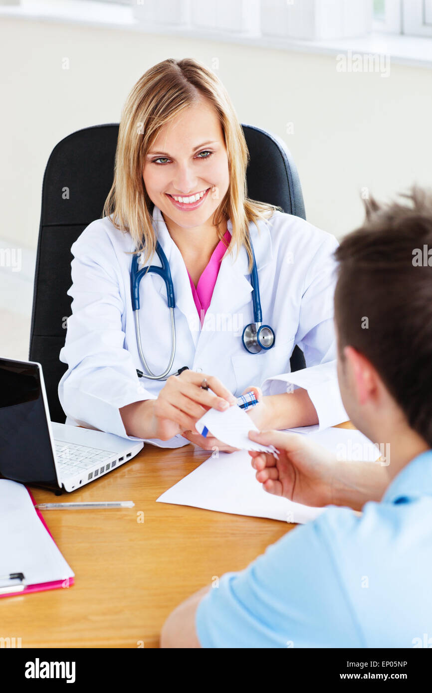 Beautiful doctor giving a prescription to her male patient sitting in