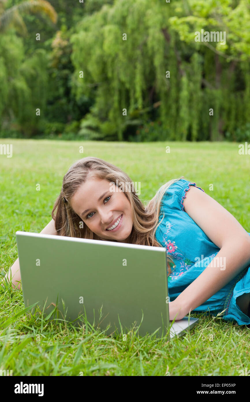 Young smiling girl using her laptop while lying on the grass Stock ...