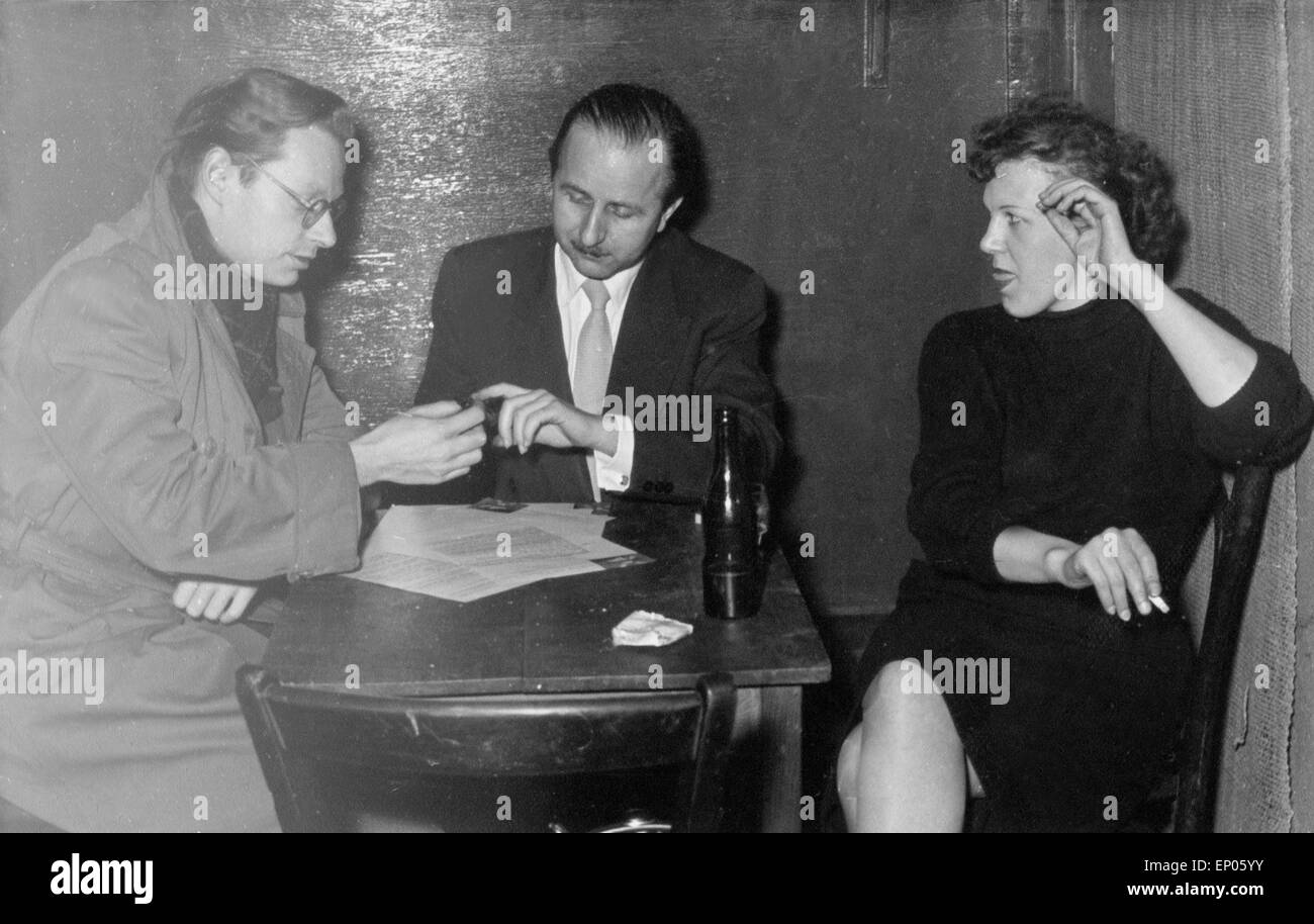 Geschäfte werden in der Atmopshäre der Hamburger Reeperbahn mit einem schriftlichen Vertrag fixiert, 1950er Jahre. Business is d Stock Photo