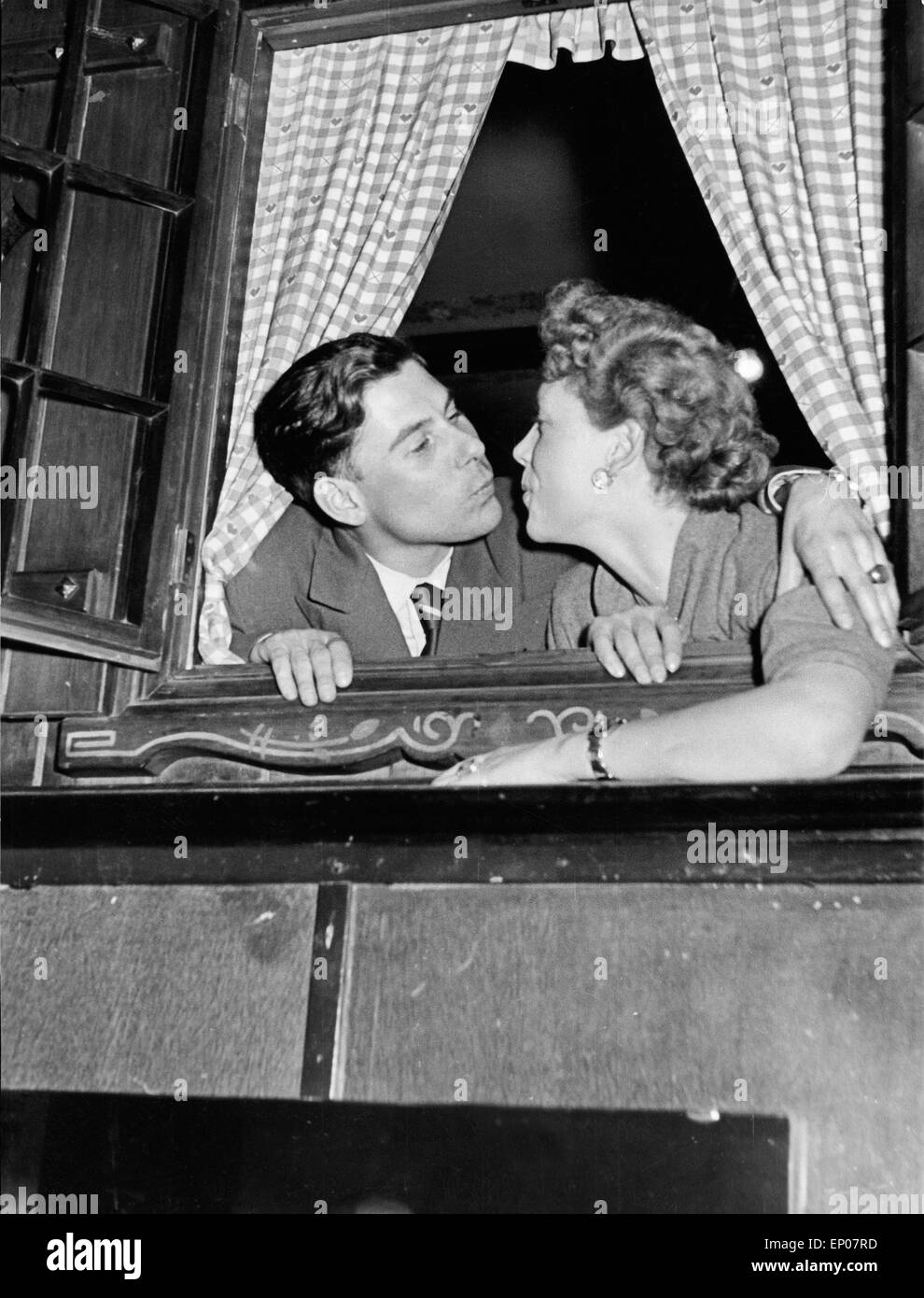 Ein junger Mann und eine junge Frau küssen sich im Fenster eines Nachtclubs auf der Reeperbahn in Hamburg, 1950er Jahre. A young Stock Photo