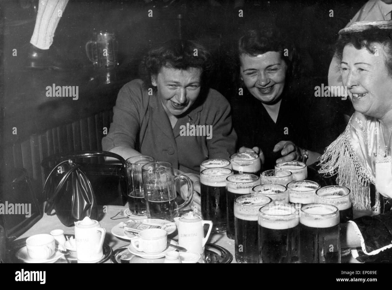 Eine Kellnerin in einem Bayerischen Lokal auf der Reeperbahn in Hamburg versorgt zwei durstige Frauen, 1950er Jahre. A waitress Stock Photo