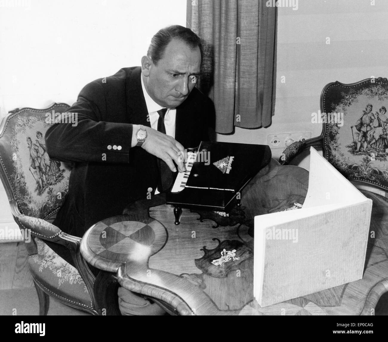 Deutscher Hörfunk- und Fernsehreporter Hermann Rockmann übet verbissen an einem Spielzeugklavier, Ende 1950er Jahre. German r Stock Photo