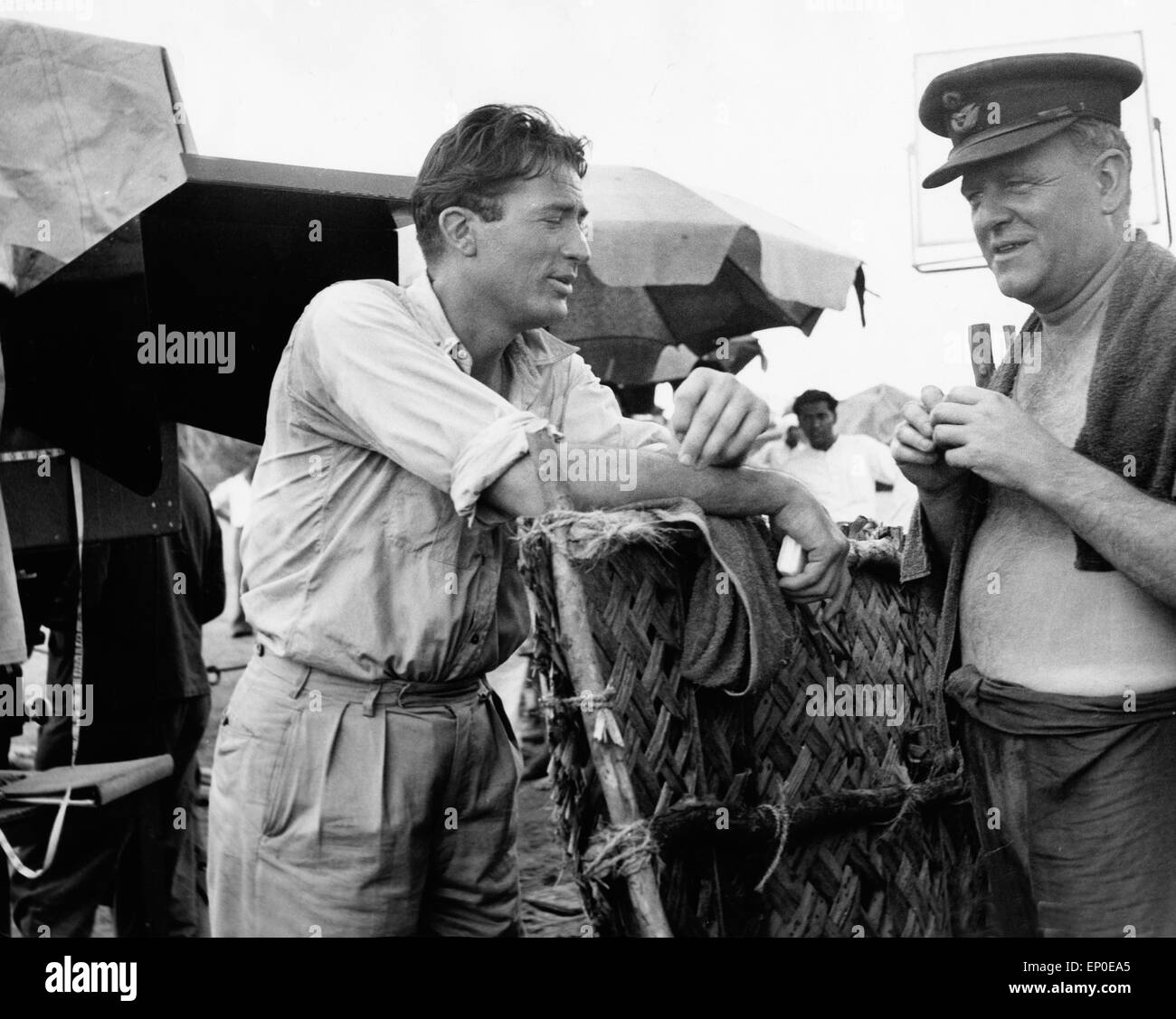 Der amerikanische Schauspieler Gregory Peck unterhält sich mit Bernard Lee, seinem Schauspielerkollegen, in einer Drehpause zum Stock Photo