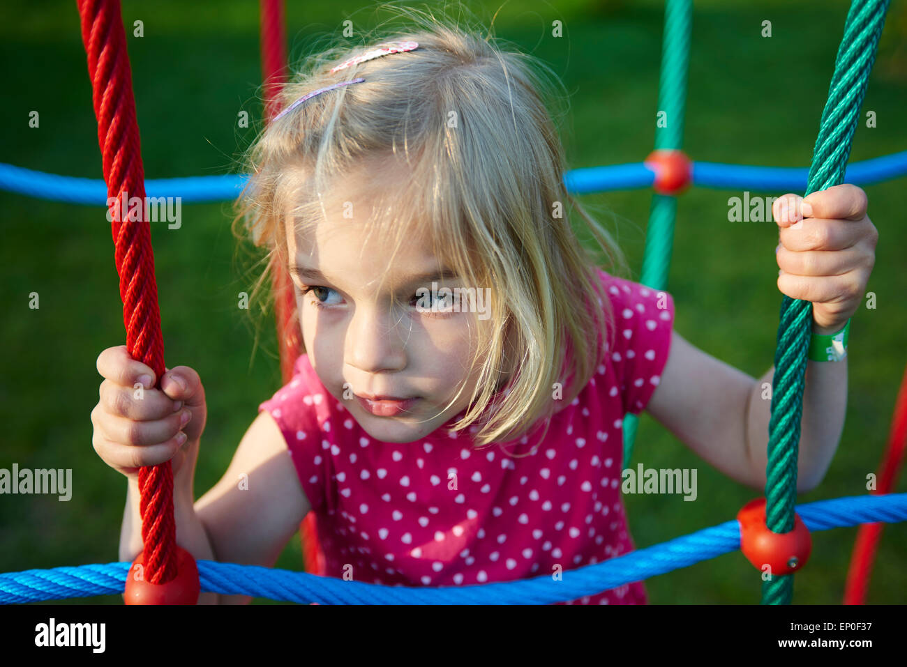 Portrait of child young blond girl climbing ropes on playground Stock ...