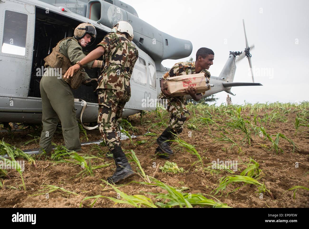 Kathmandu, Nepal. 10th May, 2015. Nepalese military service members unload supplies from a U.S. Marine UH-1Y Huey helicopter during a aid relief mission into remote areas following massive earthquakes that struck the mountain kingdom May 11, 2014 in Kavrepalanchowk District, Nepal. Stock Photo