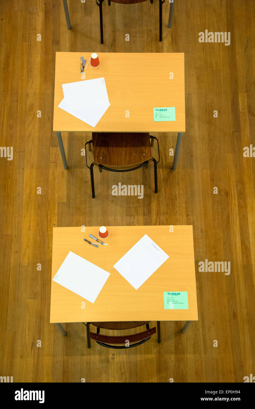 rows of tables and chairs with paper and cups waiting for the exam at ...