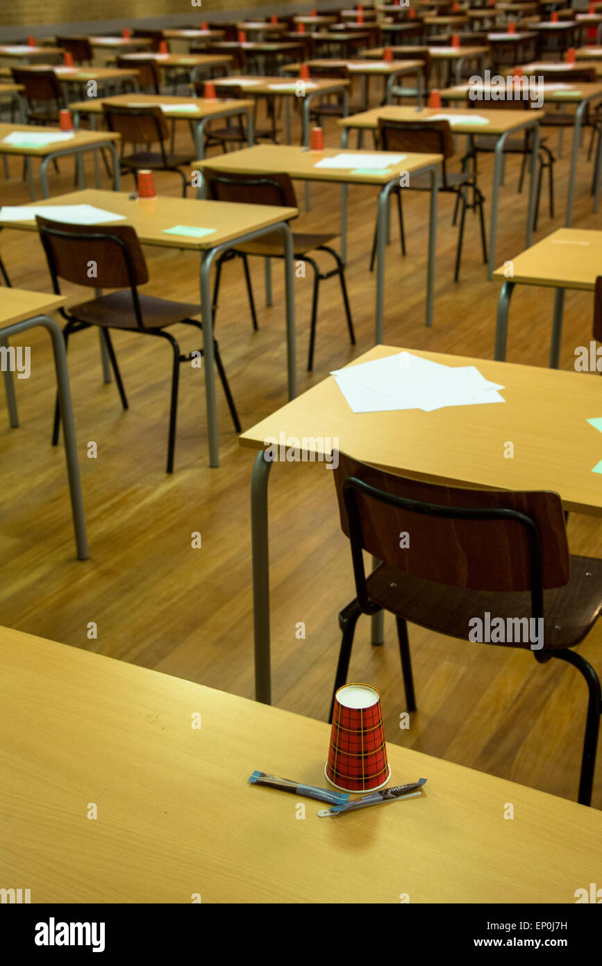 rows of tables and chairs with paper and cups waiting for the exam at ...