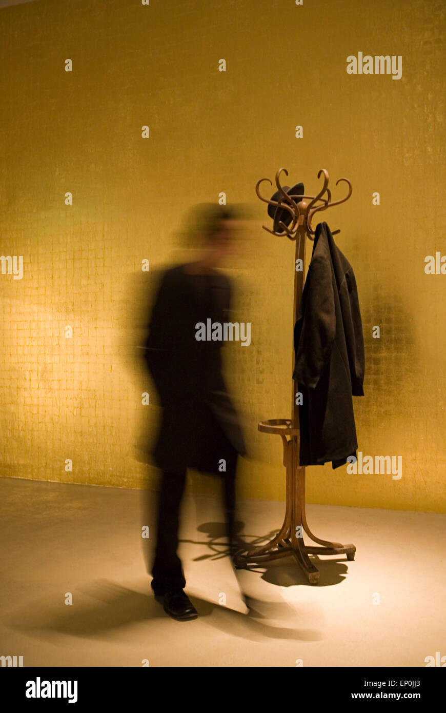 Man in motion blurred with coat stand with a jacket and a hat Germany Europe Stock Photo