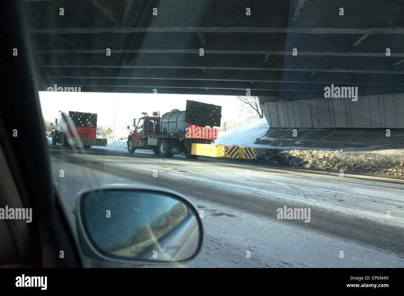 Anti-icing trucks with directional arrows melting ice from hiway 100. Minneapolis Minnesota MN USA Stock Photo