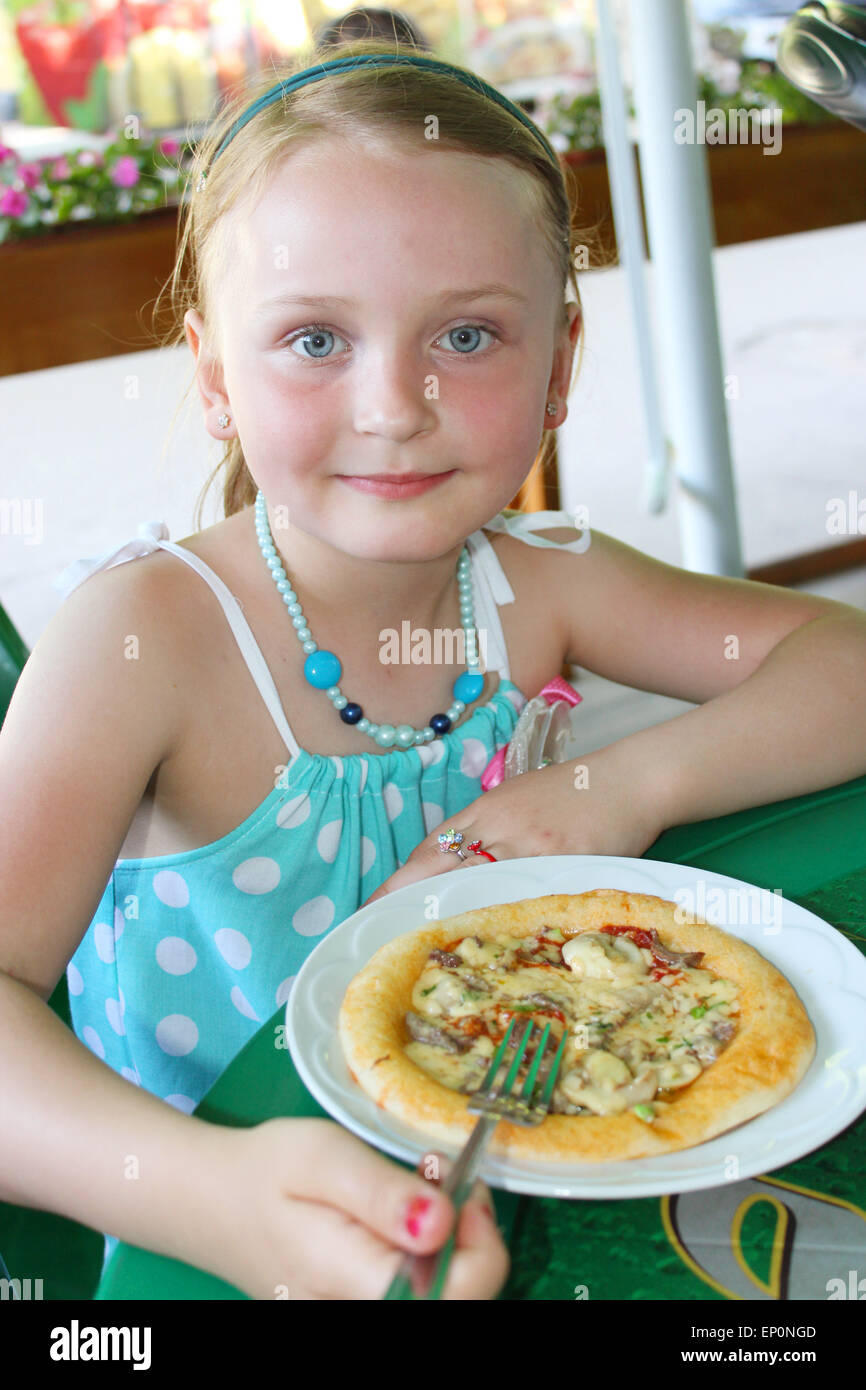 little beautiful girl eating pizza in café Stock Photo