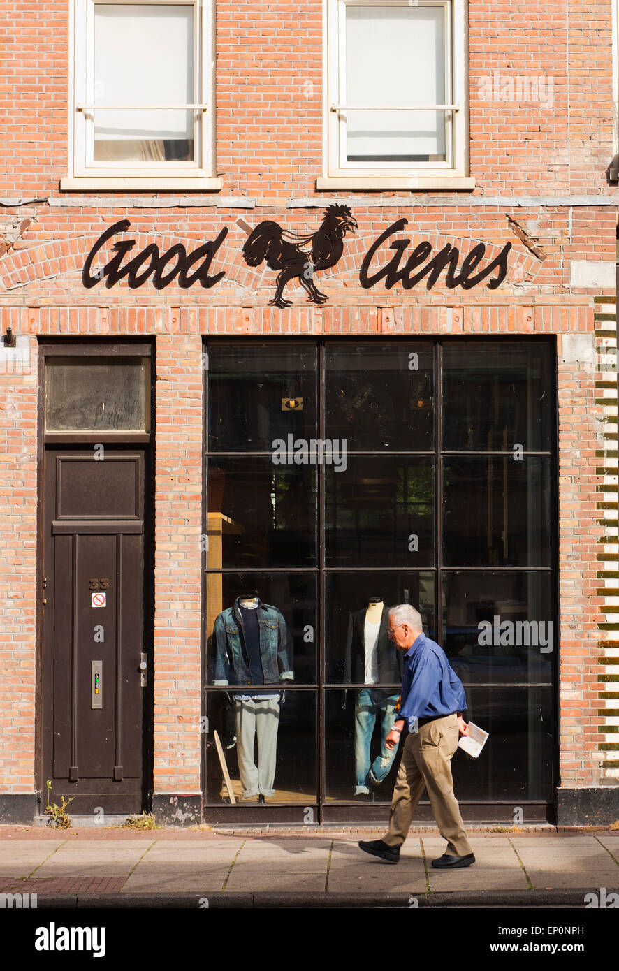 Elderly man walks past a men's clothing store called Good Genes. Stock Photo
