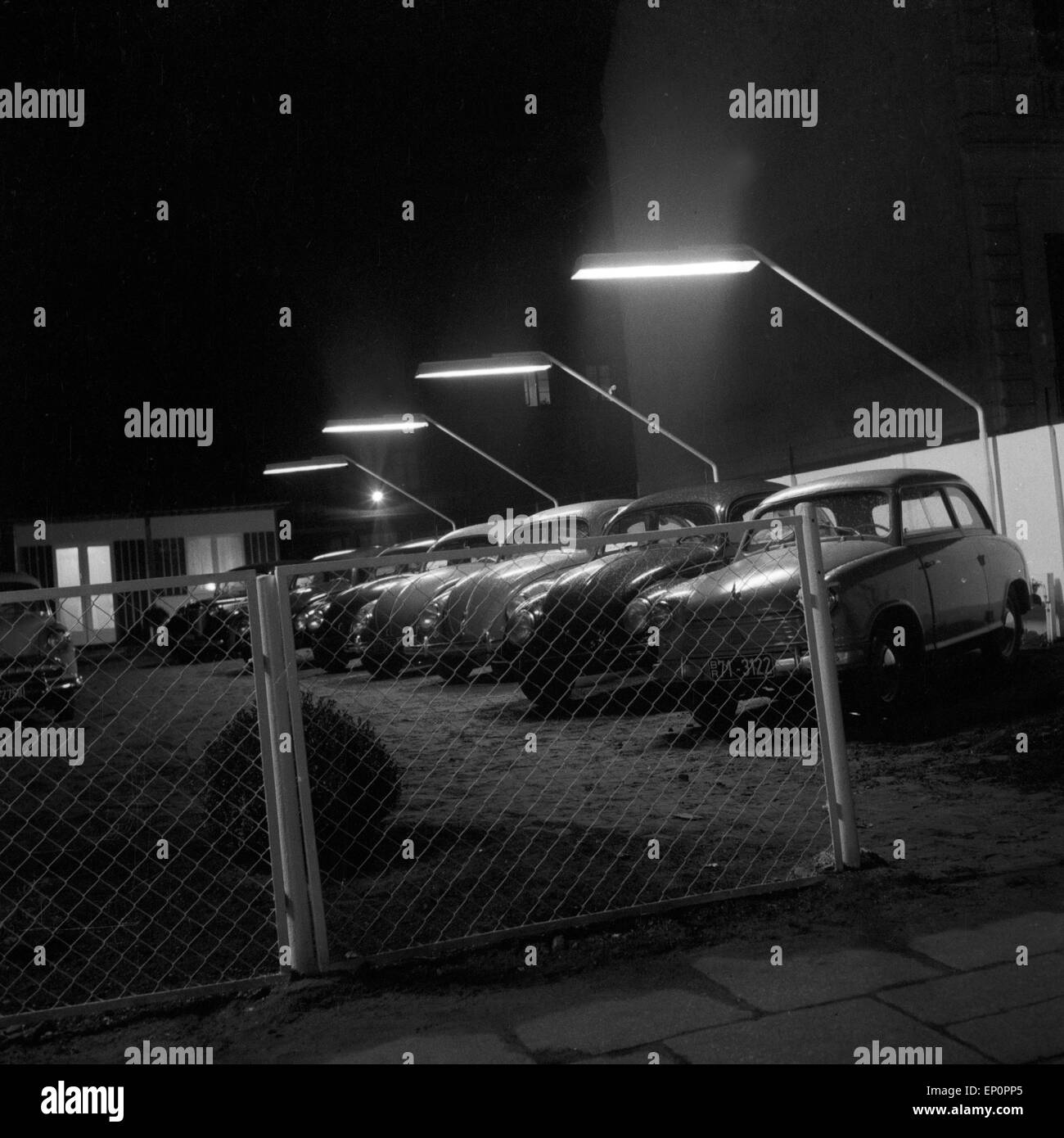 Das Angebot eines Gebrauchtwagenhändlers in der Weidenallee in Hamburg bei Nacht, 1954. Cars at a second hand car shop by night Stock Photo