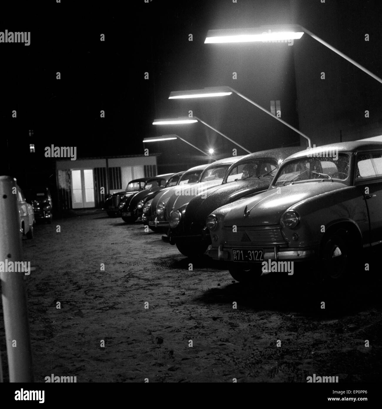 Das Angebot eines Gebrauchtwagenhändlers in der Weidenallee in Hamburg bei Nacht, 1954. Cars at a second hand car shop by night Stock Photo