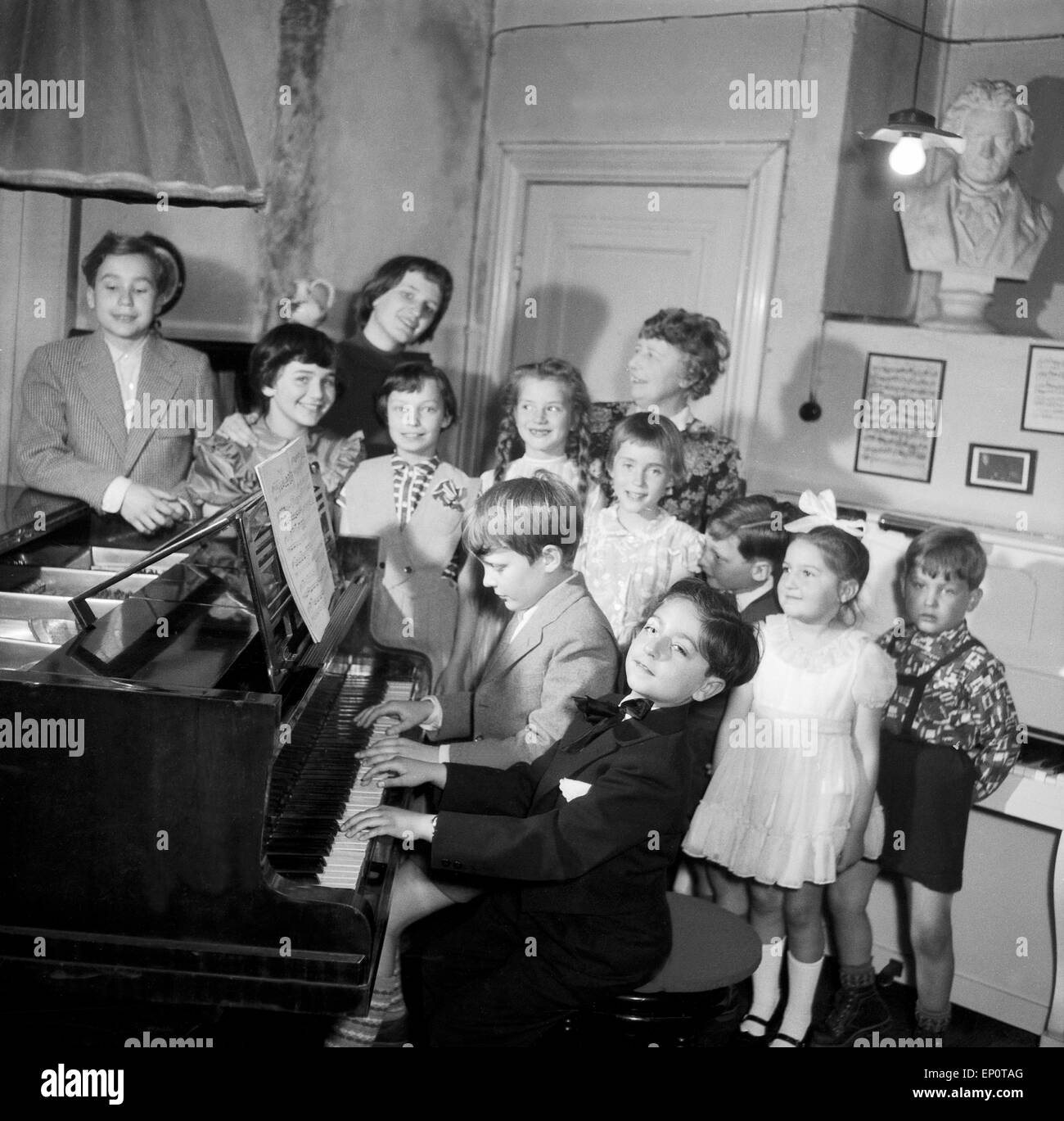 Kinder lernen bei ihrer Klavierlehrerin Klavier spielen, Hamburg 1956. Children learn to play