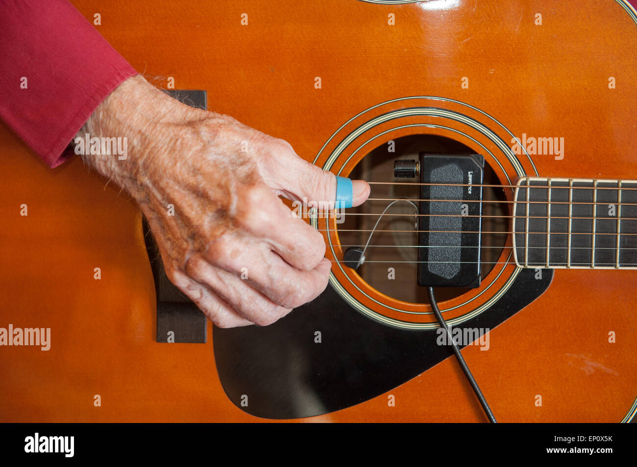 Close-up of right hand of guitar player strumming on an amplified folk guitar in Easton, MD Stock Photo