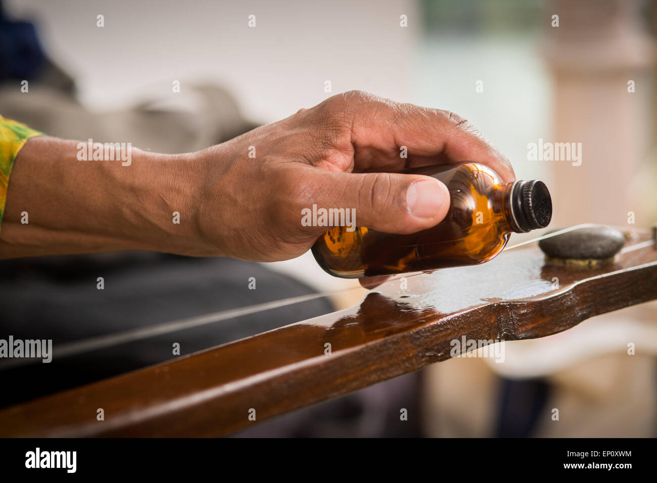 Homemade slide guitar made with wood, string and rock. A glass bottle is used for sliding on the string. Baltimore, Maryland Stock Photo