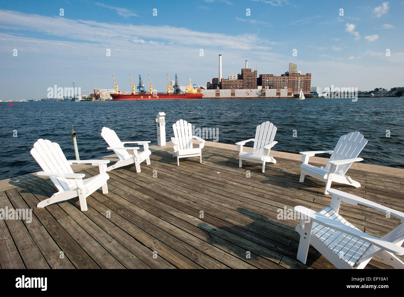 White wooden chairs on a deck by the Baltimore harbor, near Fells Point, Maryland, USA Stock Photo