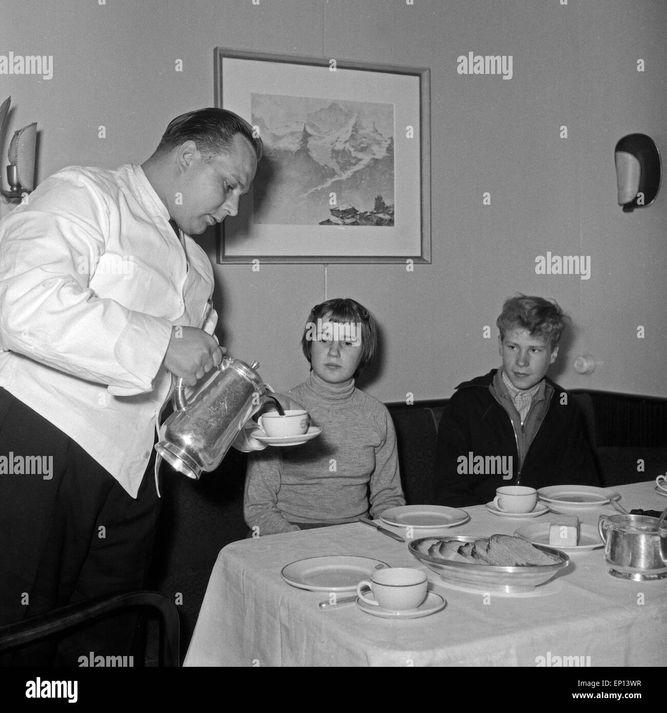Ein Kellner serviert zwei Kindern einen Kaffee im Restaurant eines Schiffes, Deutschland 1950er Jahre. A waiter serving coffee t Stock Photo