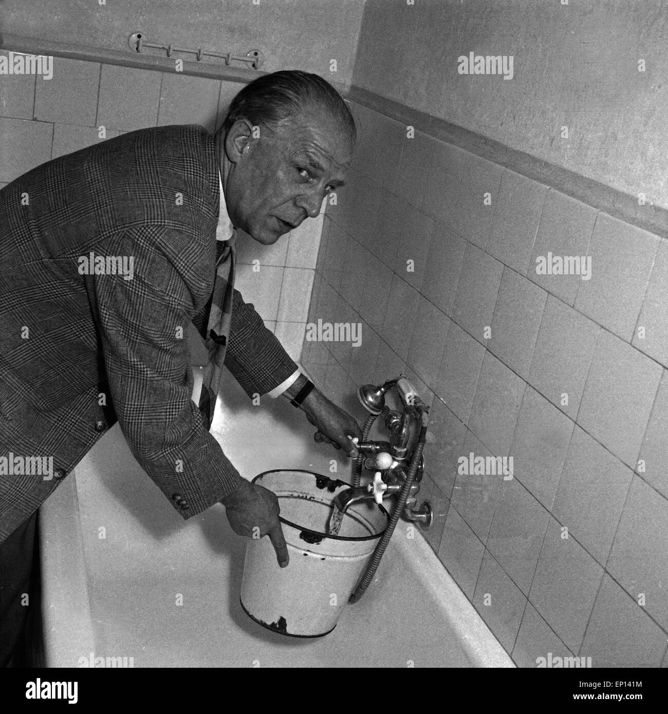 Deutscher Schriftsteller und Journalist Albin Stuebs füllt einen Eimer mit Wasser, Deutschland 1950er Jahre. German author an Stock Photo