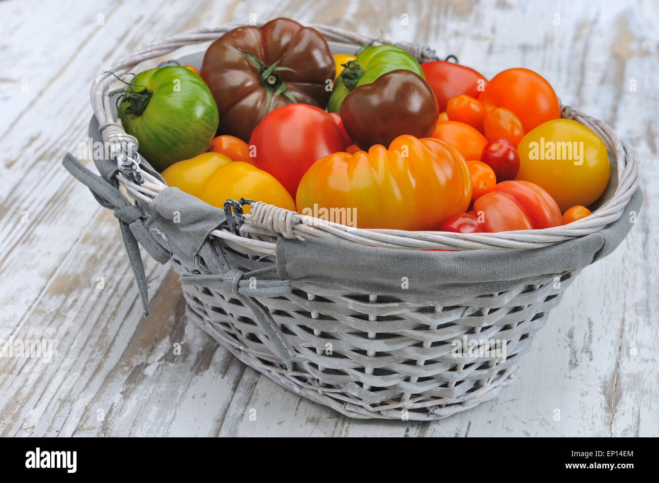 differents color varieties of tomatoes in basket on white background ...