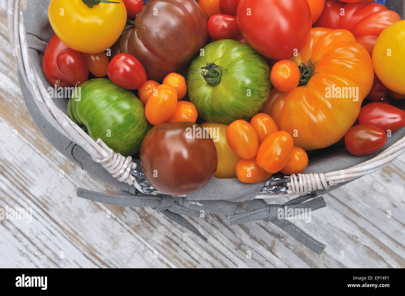 differents color varieties of tomatoes in basket on white background ...