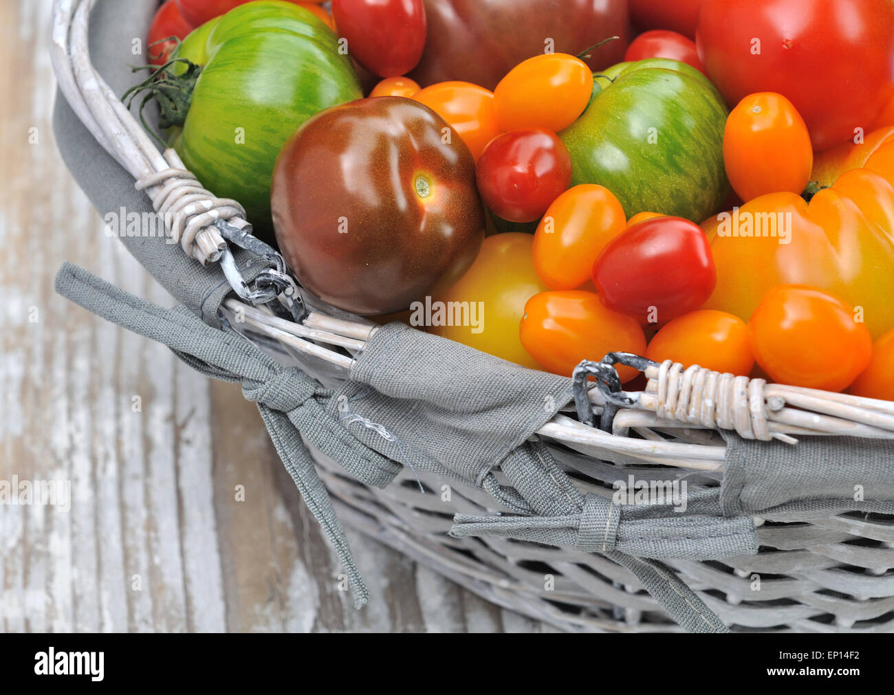 differents color varieties of tomatoes in basket on white background ...