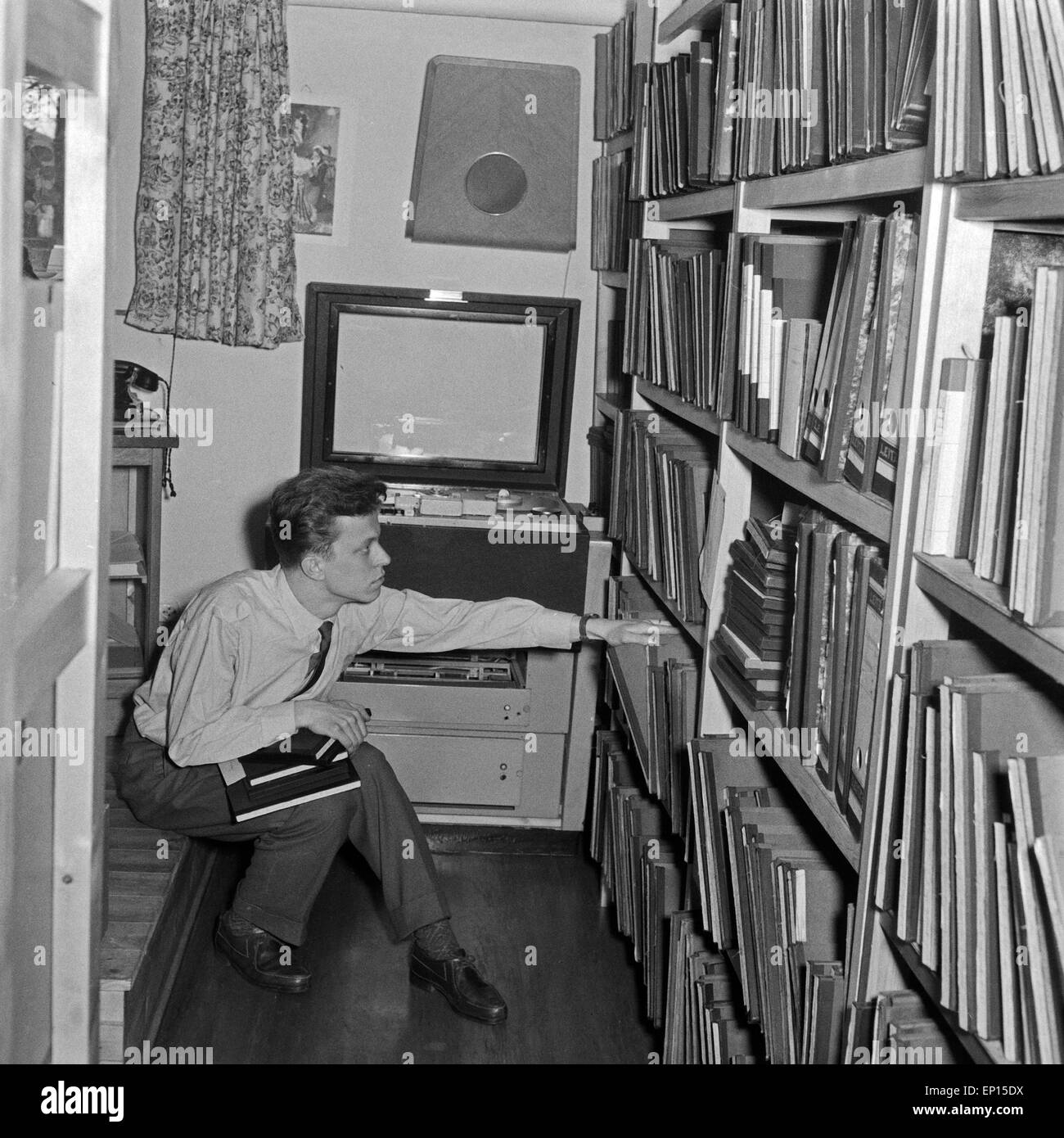 Alltag im NDR: ein Redakteur ist im Archiv auf der Suche nach Bild- und Bewegtbildmaterial, Deutschland 1950er Jahre. Workaday l Stock Photo