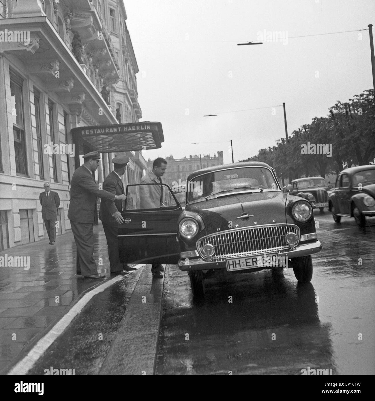 Ein Chauffeur holt seine Fahrgäste vor dem Restaurant Haerlin in Hamburg ab, Deutschland 1950er Jahre. A chauffeur picking up hi Stock Photo