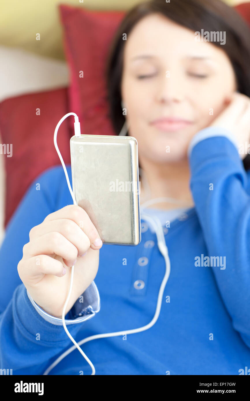 Caucasian young woman listening music lying on a sofa Stock Photo - Alamy