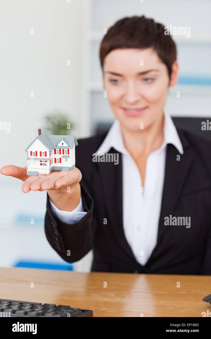 Portrait of a businesswoman showing a miniature house Stock Photo - Alamy