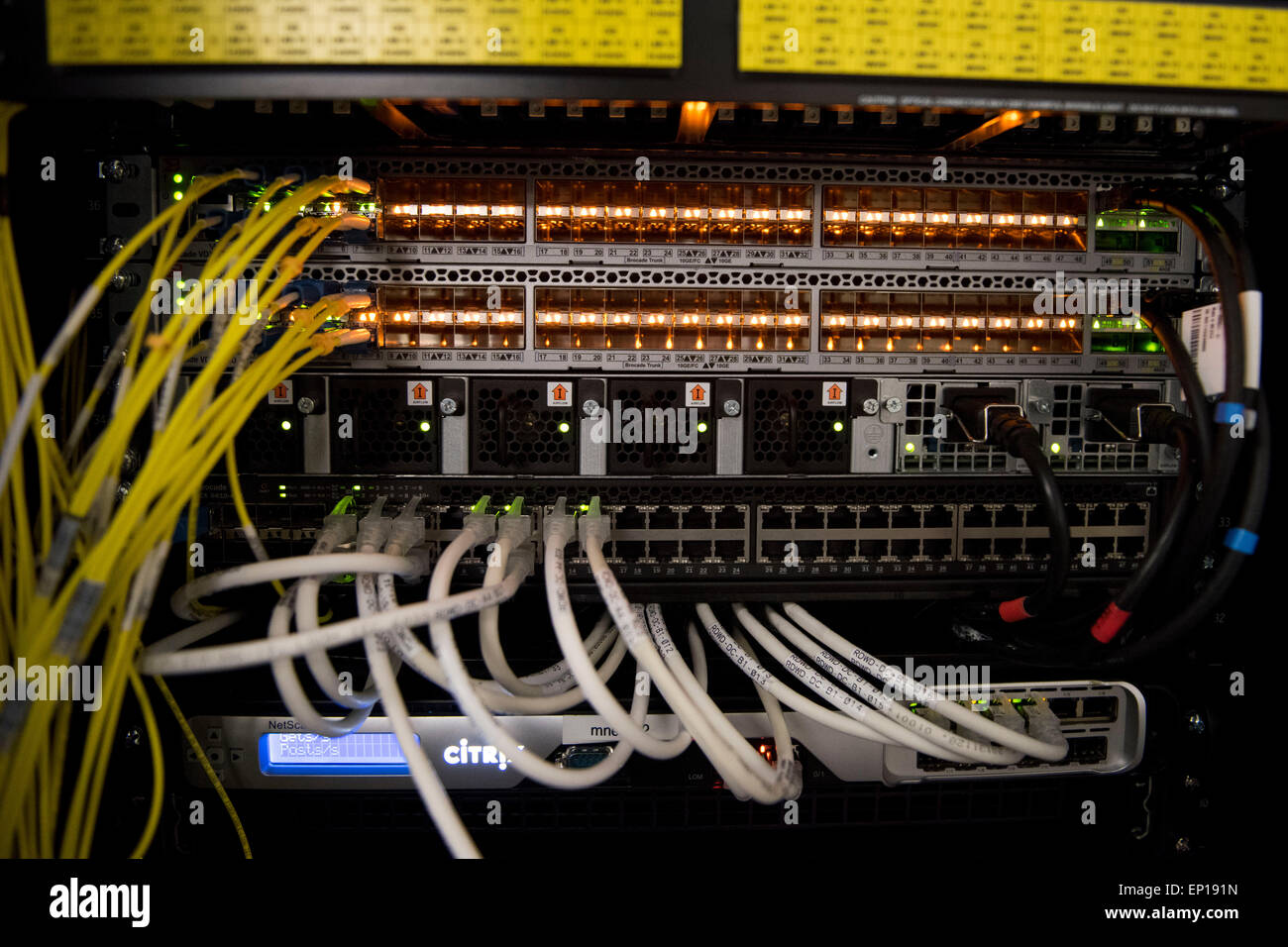 The rear of a computer server used for cloud computing showing routers and network cables. Stock Photo