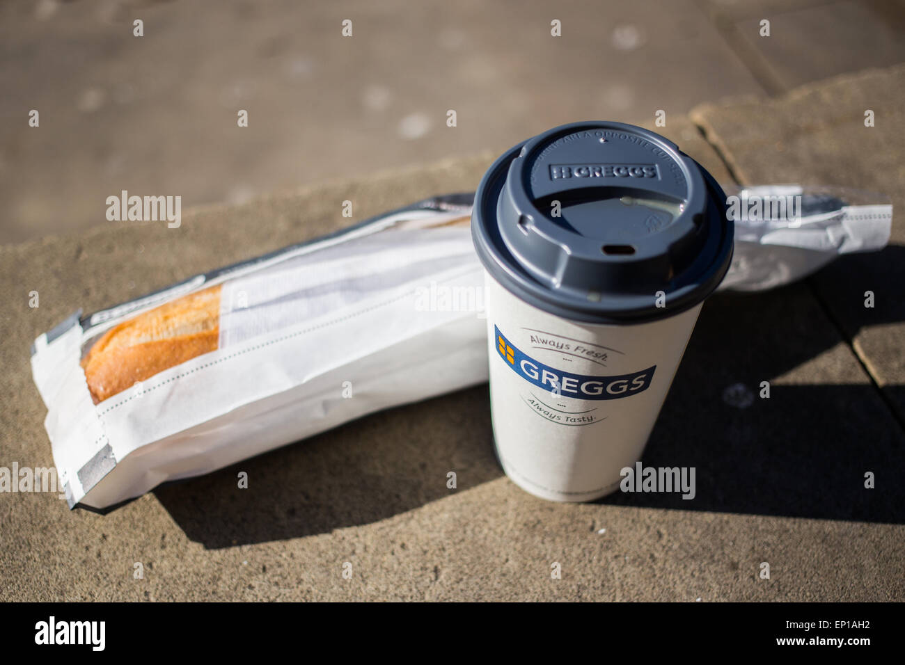 Picture of a Greggs bacon baguette and a cup of tea taken outside Stock