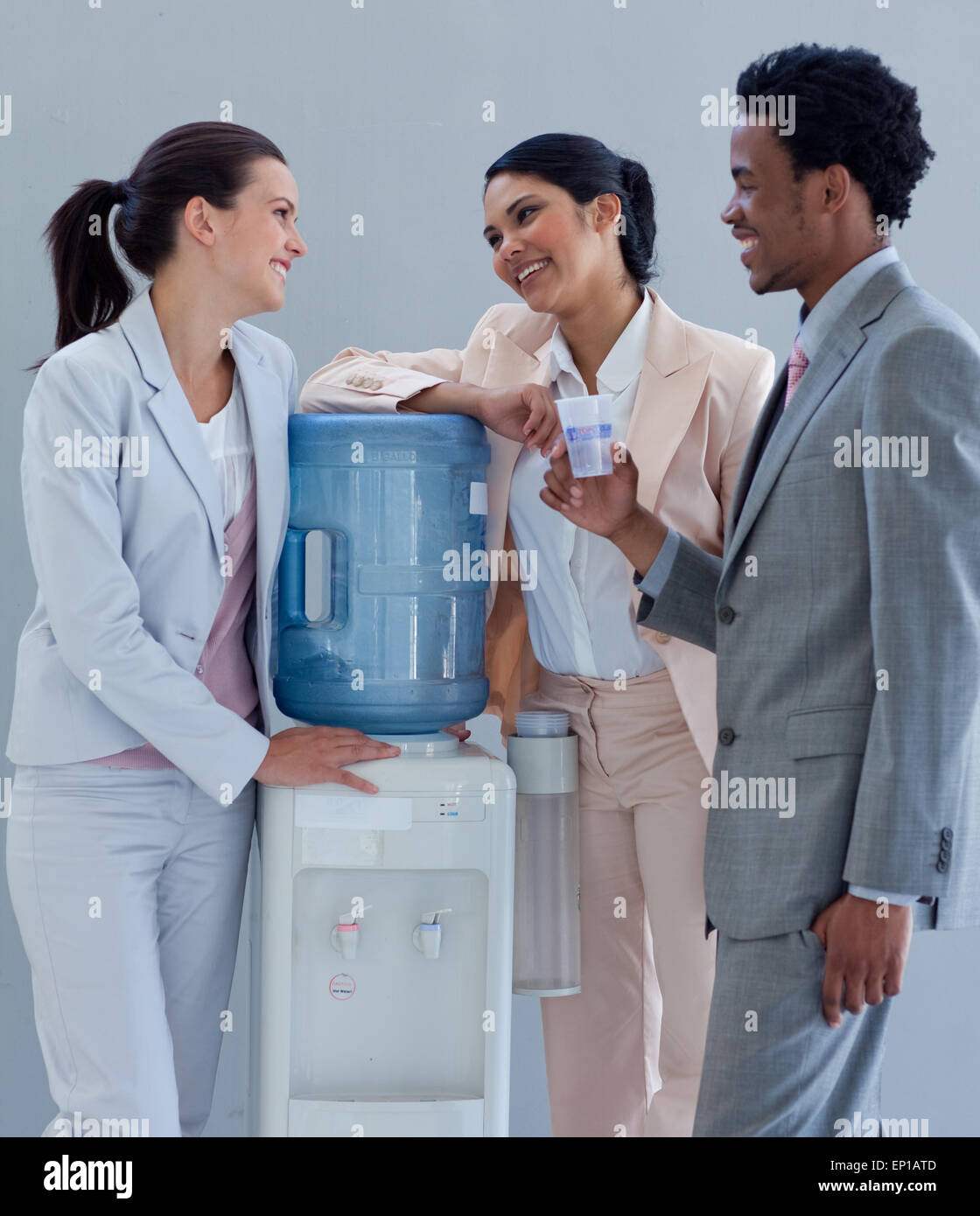 Business people speaking next to a water cooler Stock Photo Alamy