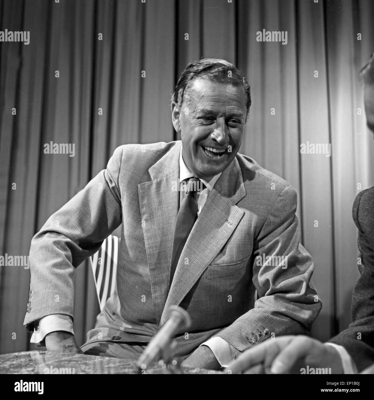 Deutscher Schauspieler Hans Söhnker lachend in einem Interview, Deutschland 1950er Jahre. German actor Hans Soehnker laughing Stock Photo