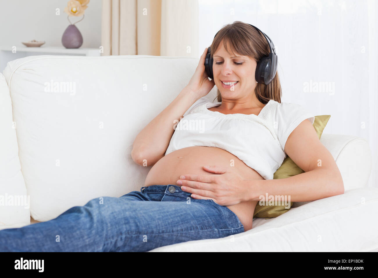 Smiling pregnant woman listening to music Stock Photo - Alamy