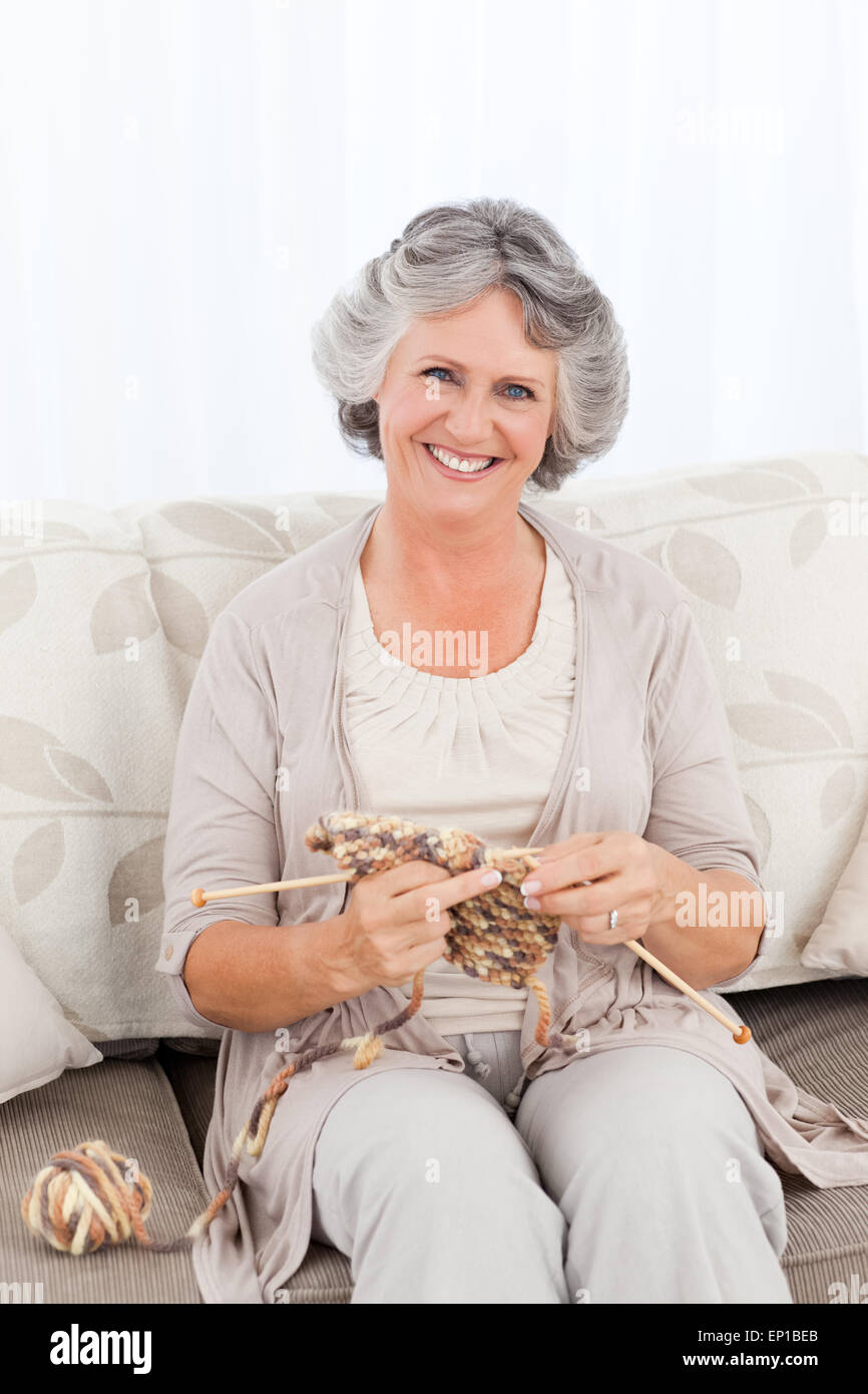 Senior woman knitting on her sofa Stock Photo - Alamy