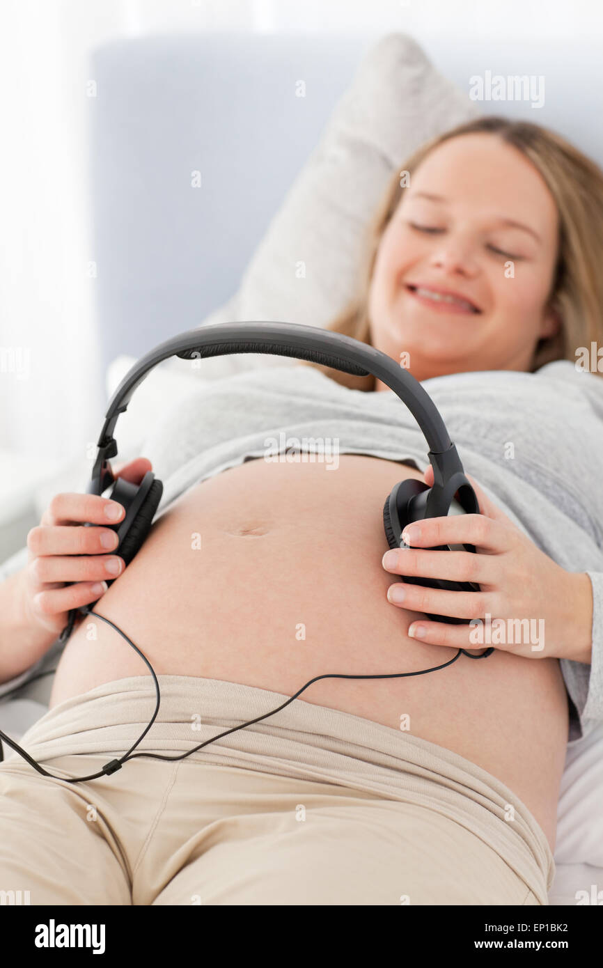 Happy pregnant woman putting headphones on her belly Stock Photo Alamy